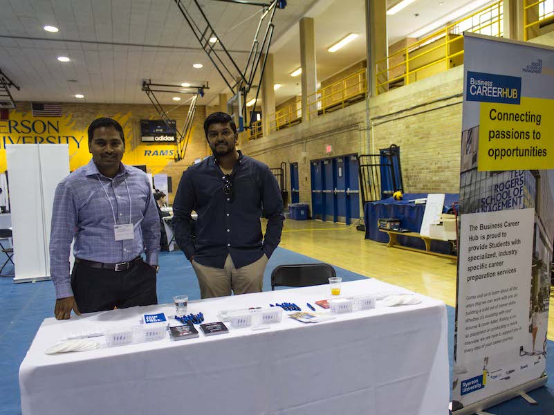 Two men at their reception desk at the international job fair
