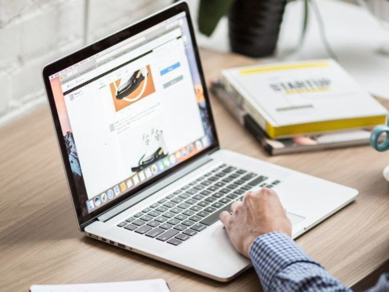 A hand on a laptop keyboard