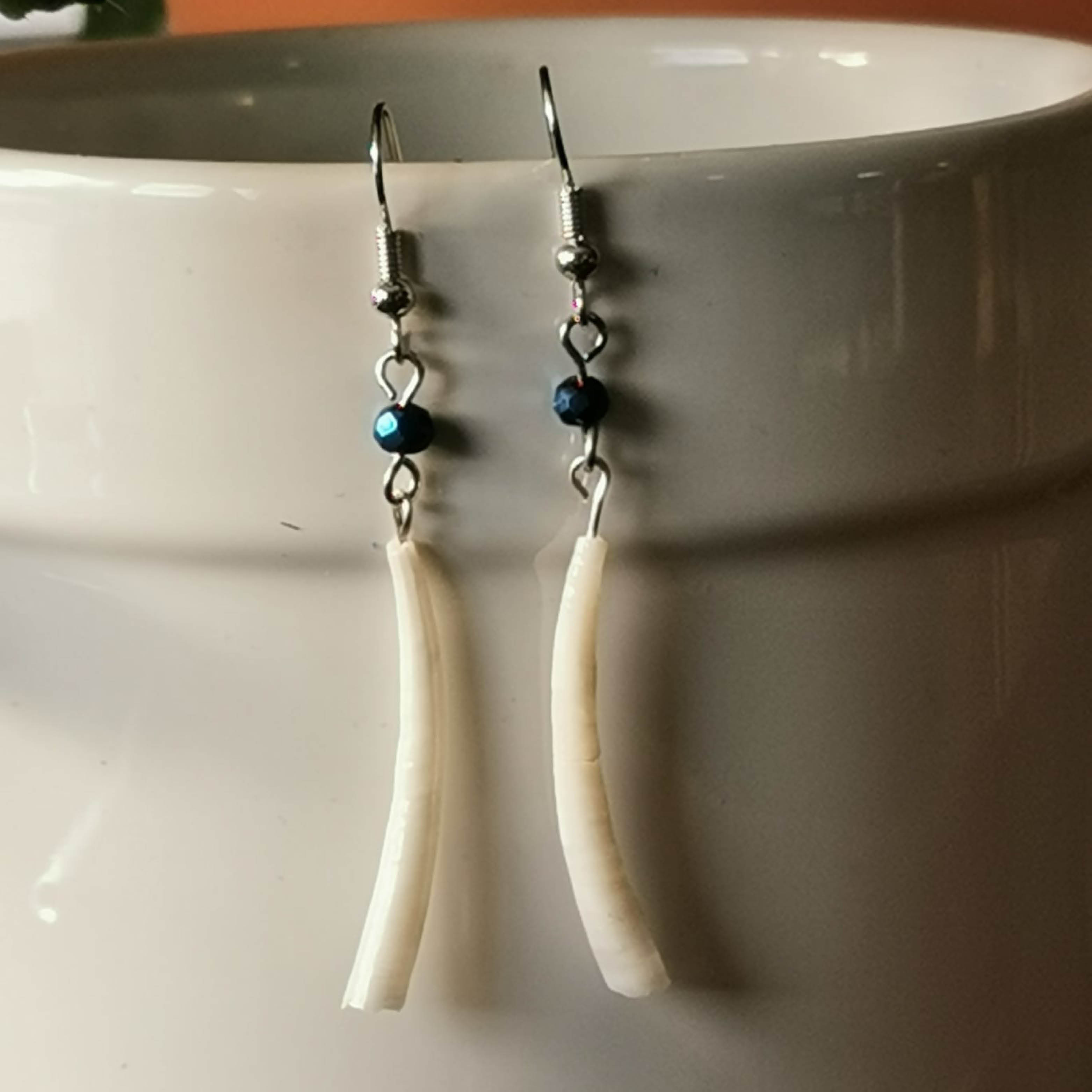 White Horse Rider Co. long and white dangling earrings.