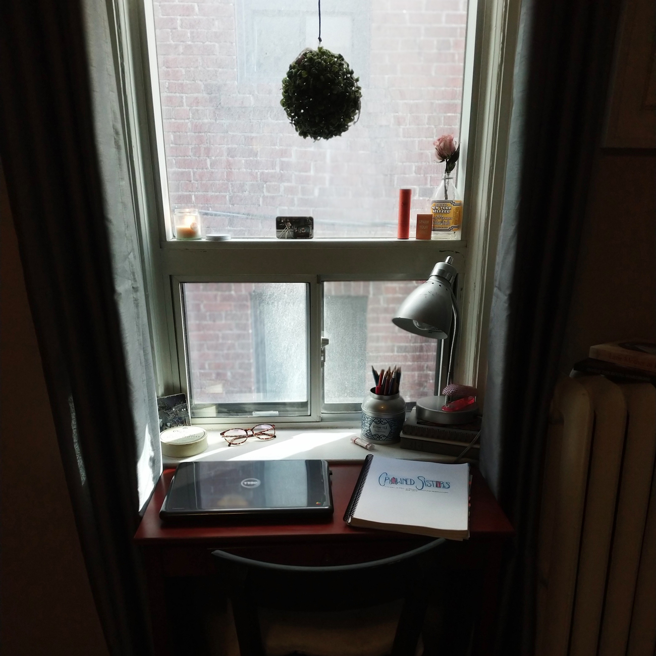 An image capturing the essentials of a graduate school student who's research focuses on Fashion History, a laptop with a study lamp