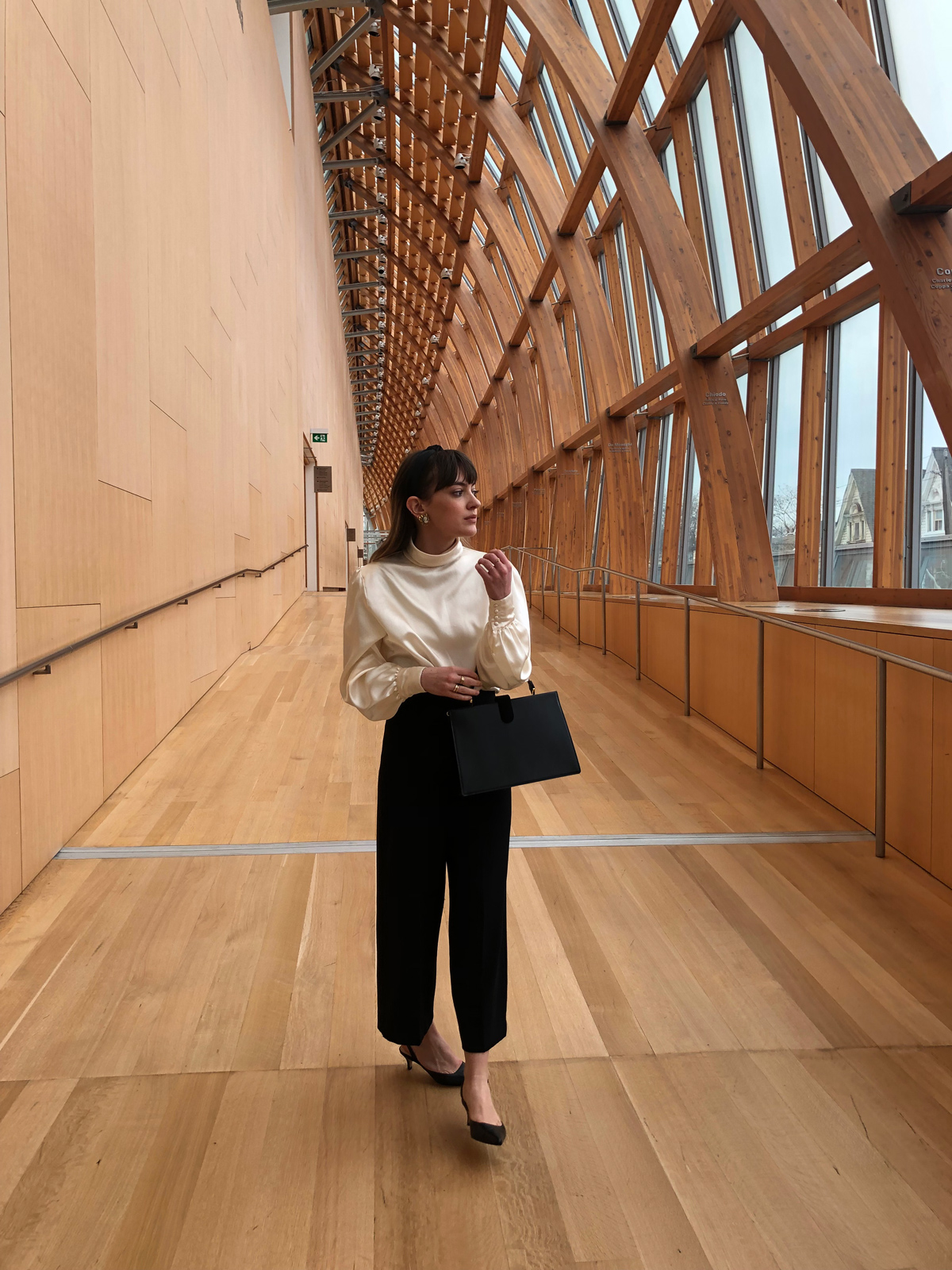 A graduate student caught in thought while walking through a gallery