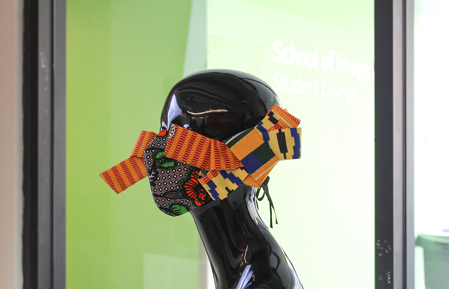 Side view of a COVID-19 fabric Demestik Bowtie Sculpted Mask on a Black plastic mannequin head 