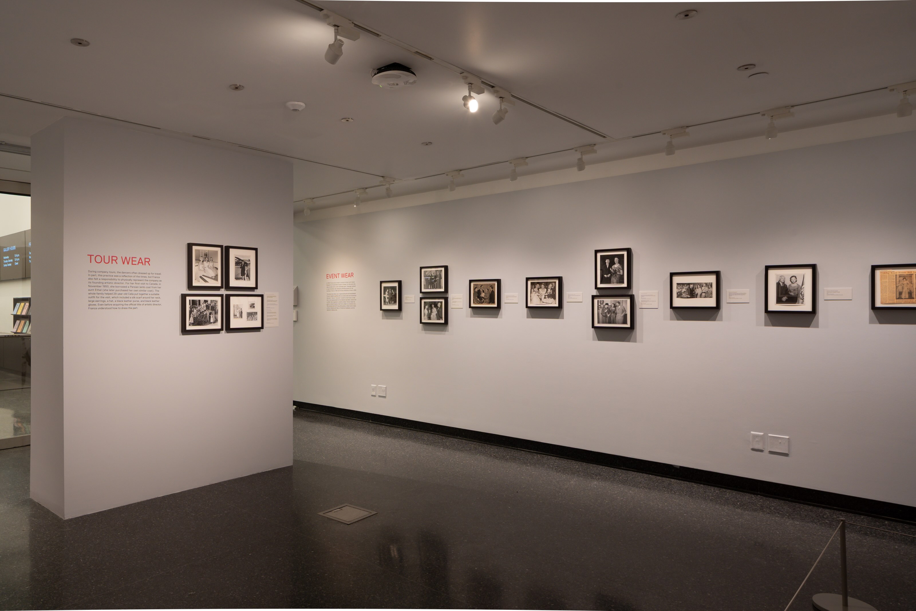 A wall mounted with multiple photos, mostly black and white. 