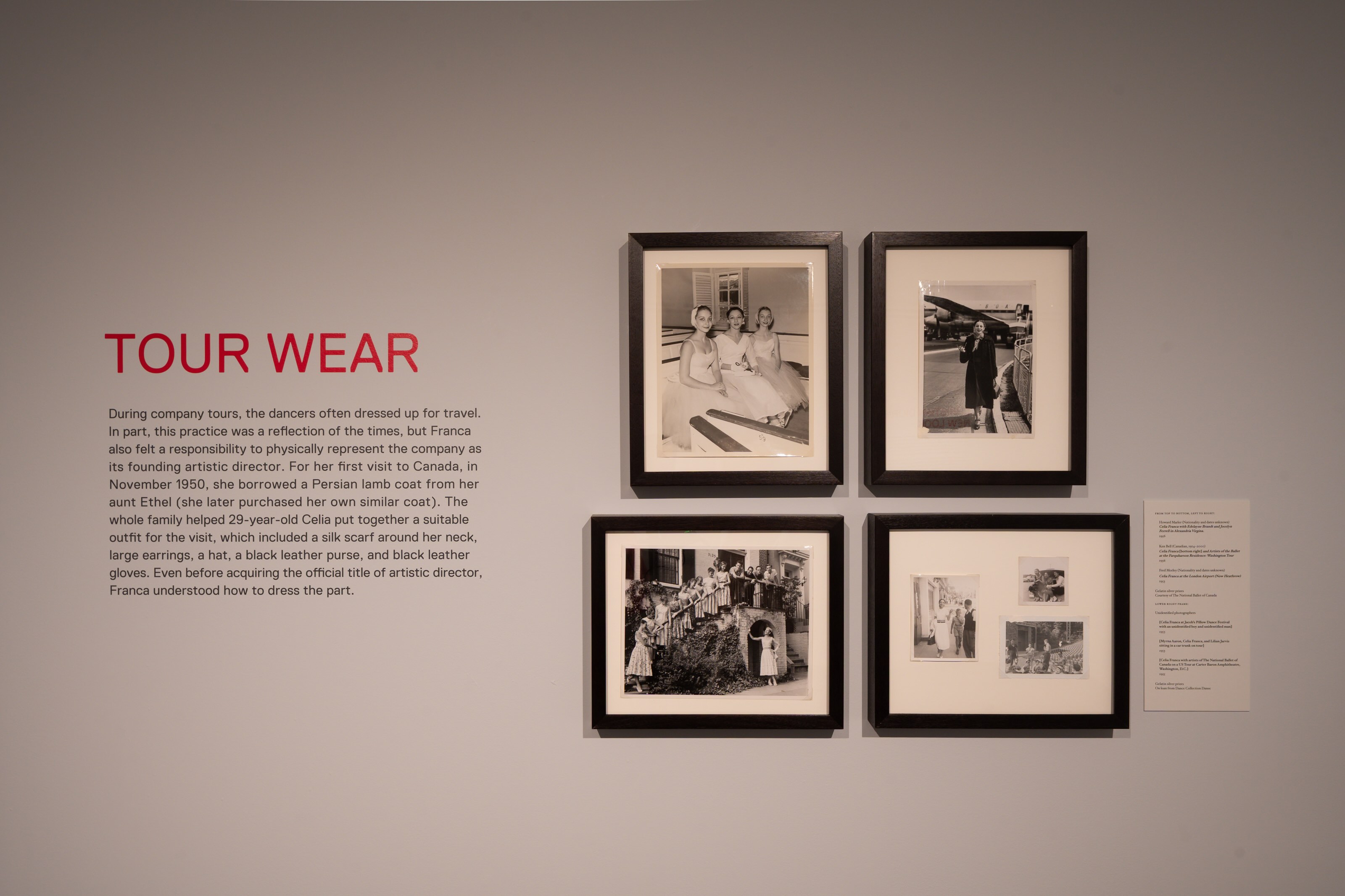 A wall with exhibition text and four photos to the right. Heading reads “Tour Wear” in bright pink text. 