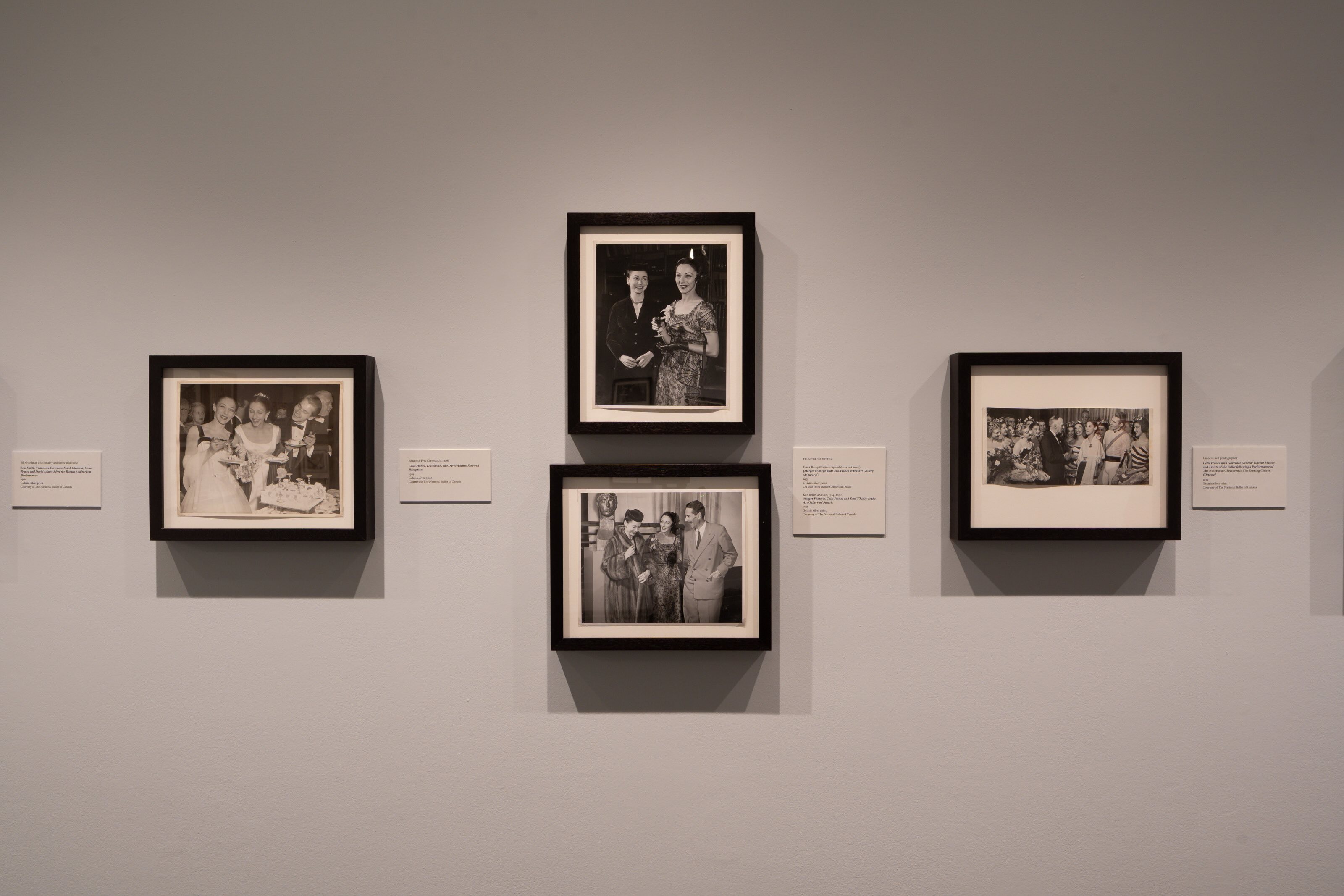 Four black and white framed photos on the wall with accompanying captions. 