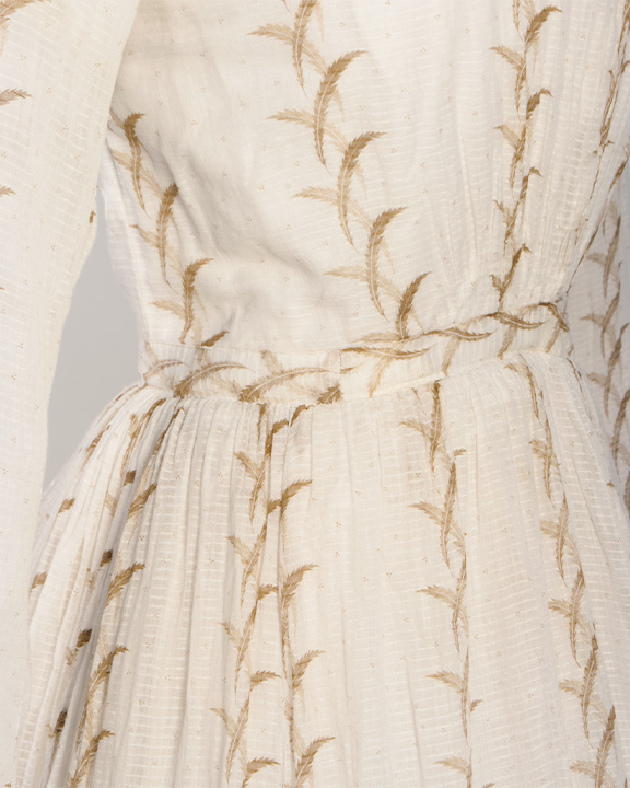 Close up of waist detail of a white printed 1860s dress