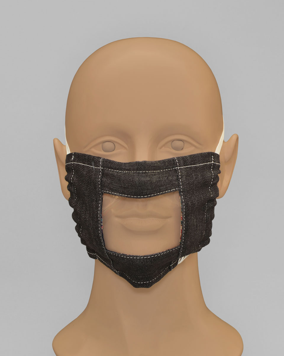 Mannequin head wearing a denim face mask with a plastic lip reader panel