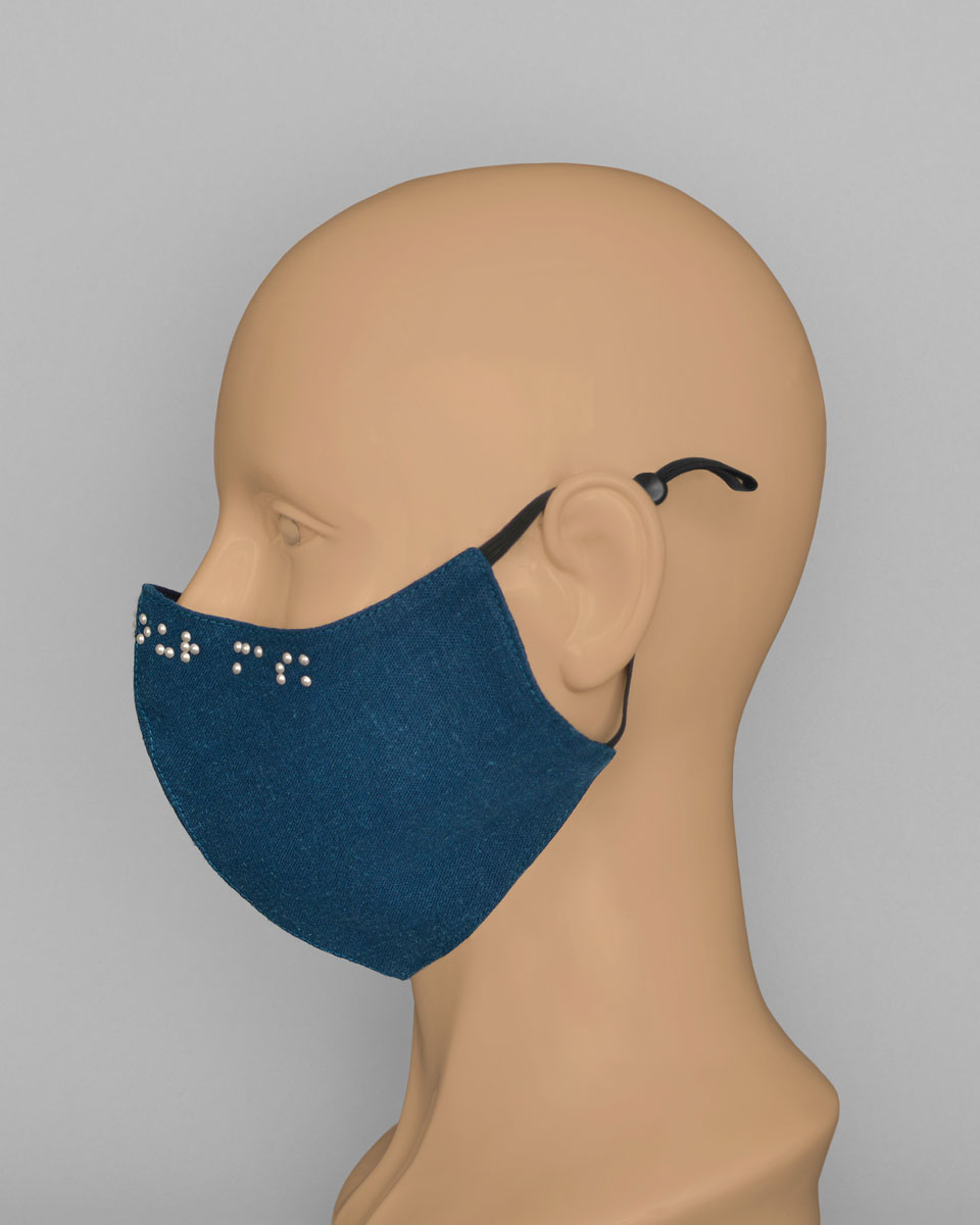Side view of the blue Braille face mask with black ear loops
