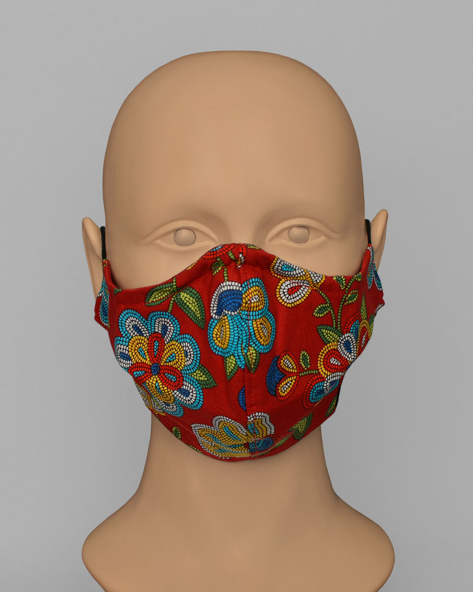 Mannequin head wearing a red face mask with a colourful floral pattern.