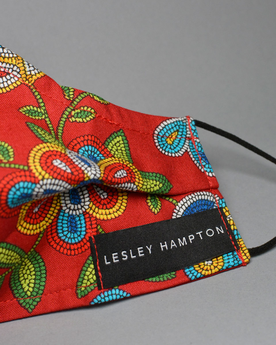 Label on the red floral face mask which reads Lesley Hampton