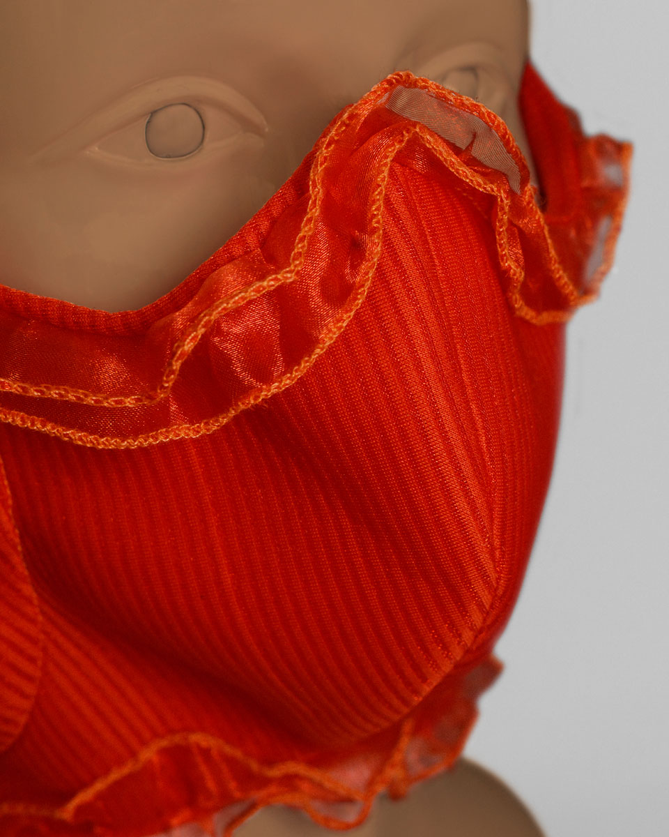 Detail shot of the orange face mask with ruffled trim