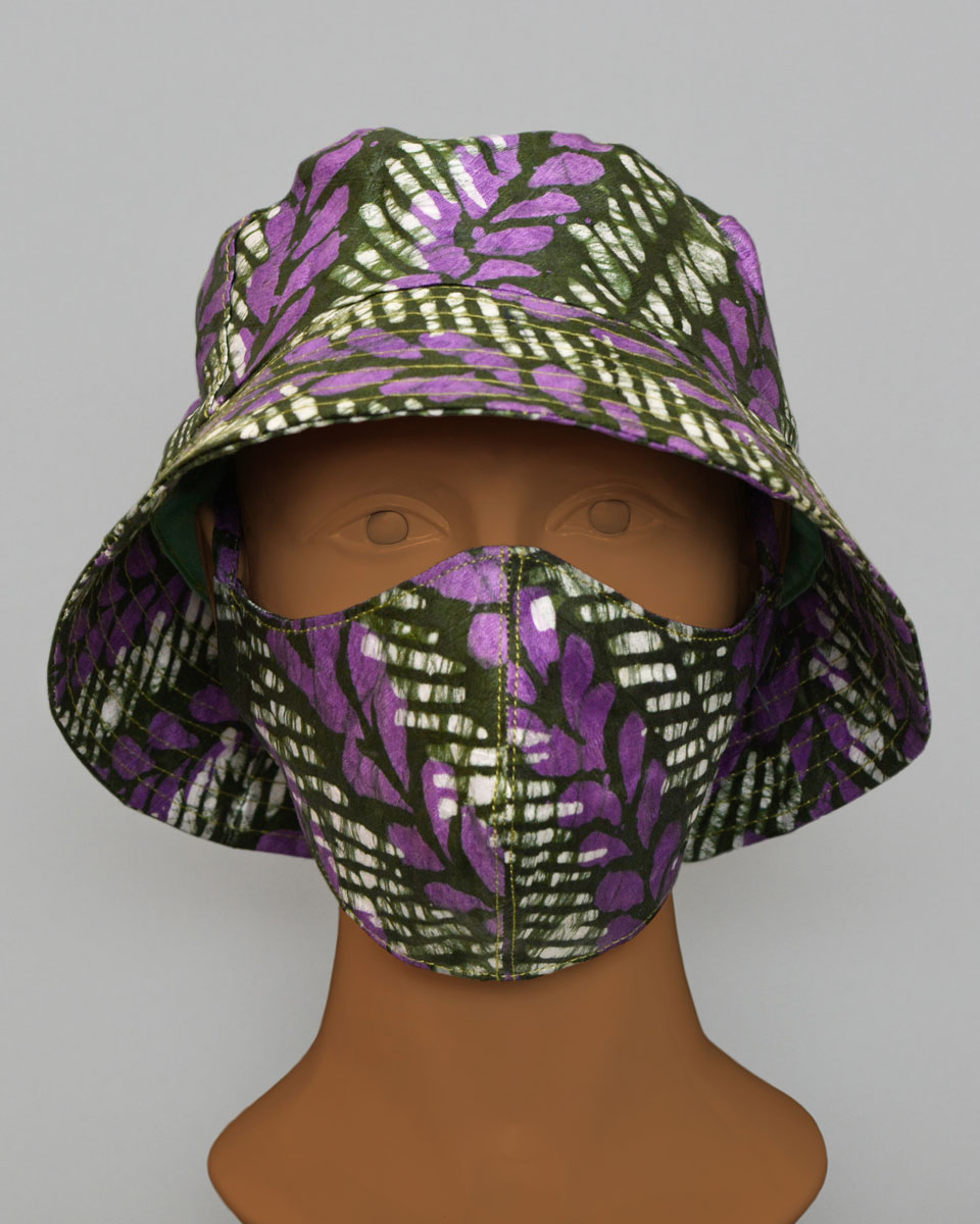 Mannequin head wearing a green, white and purple patterned hat and mask