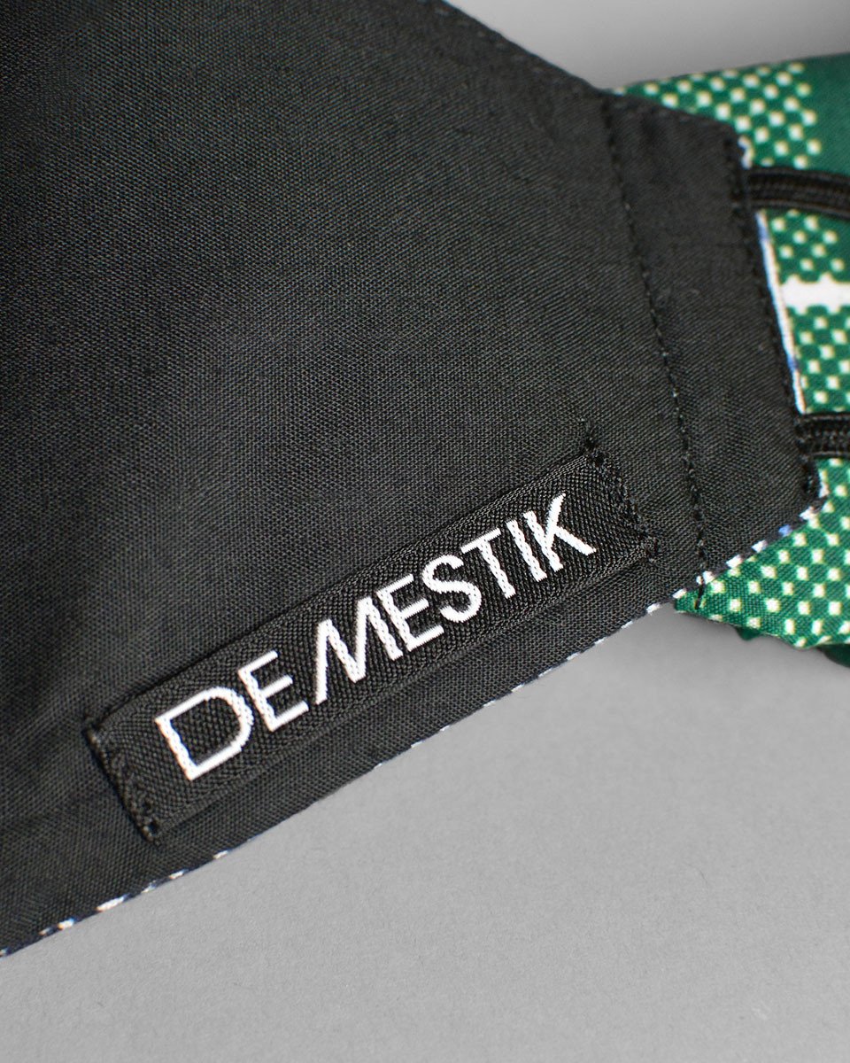 The label on the inside of the mask that reads Demestik