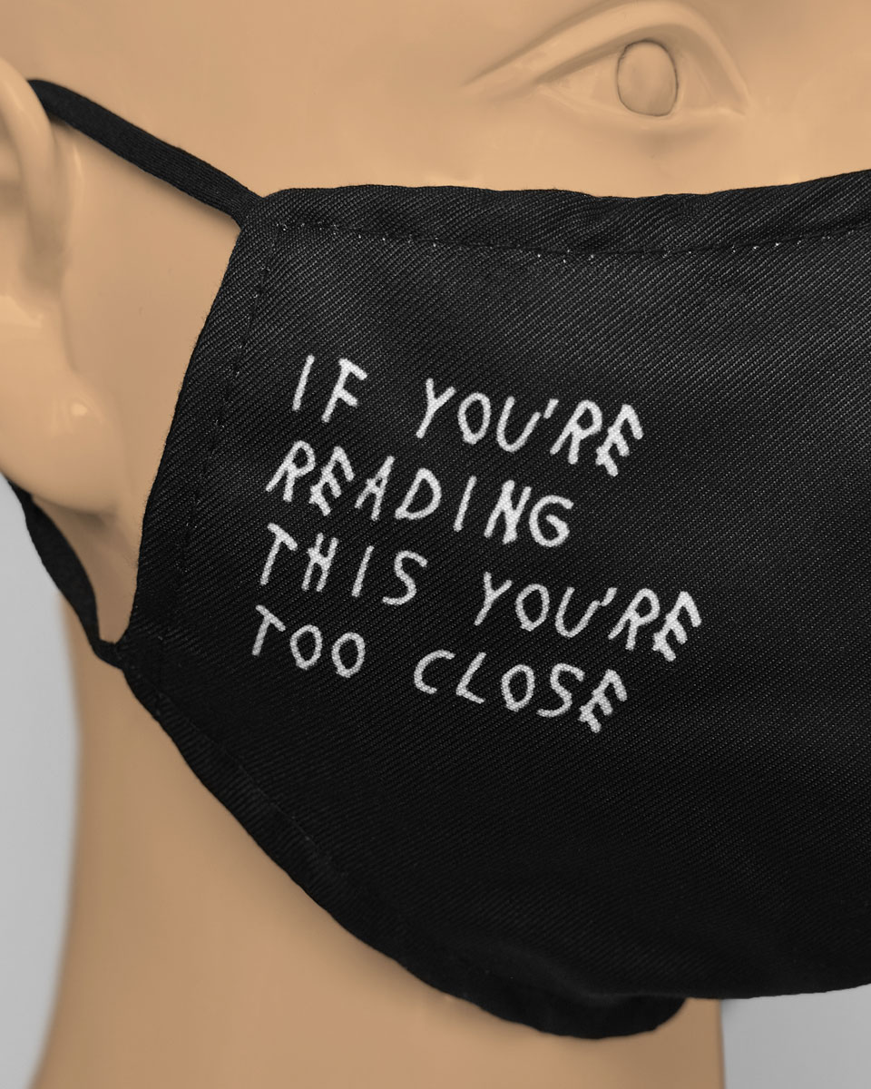 Side view of mask which reads "if you're reading this you're too close"
