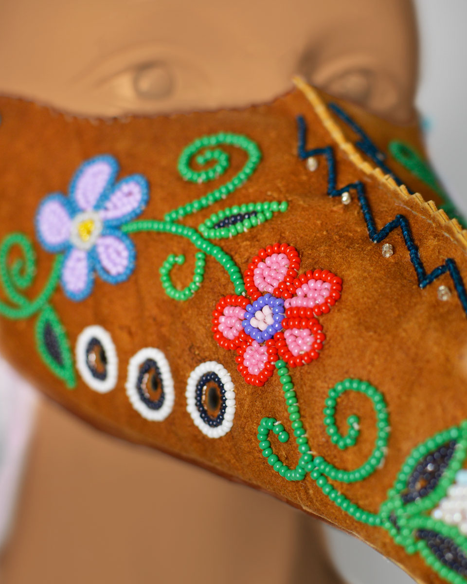 Detail shot of the colourful beaded floral designs on the mask