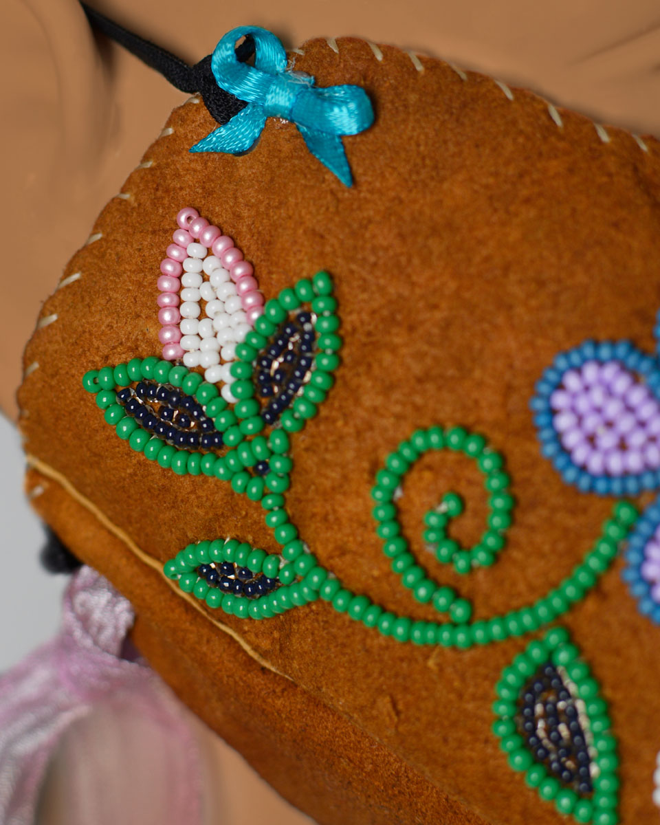 A beaded floral design on the side of the face mask.