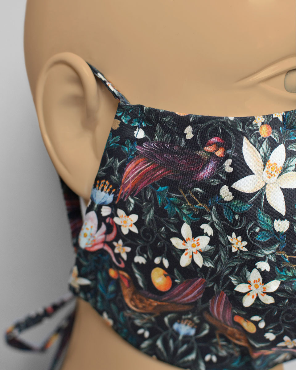 Detail shot of the mask with a fruit, floral and bird pattern