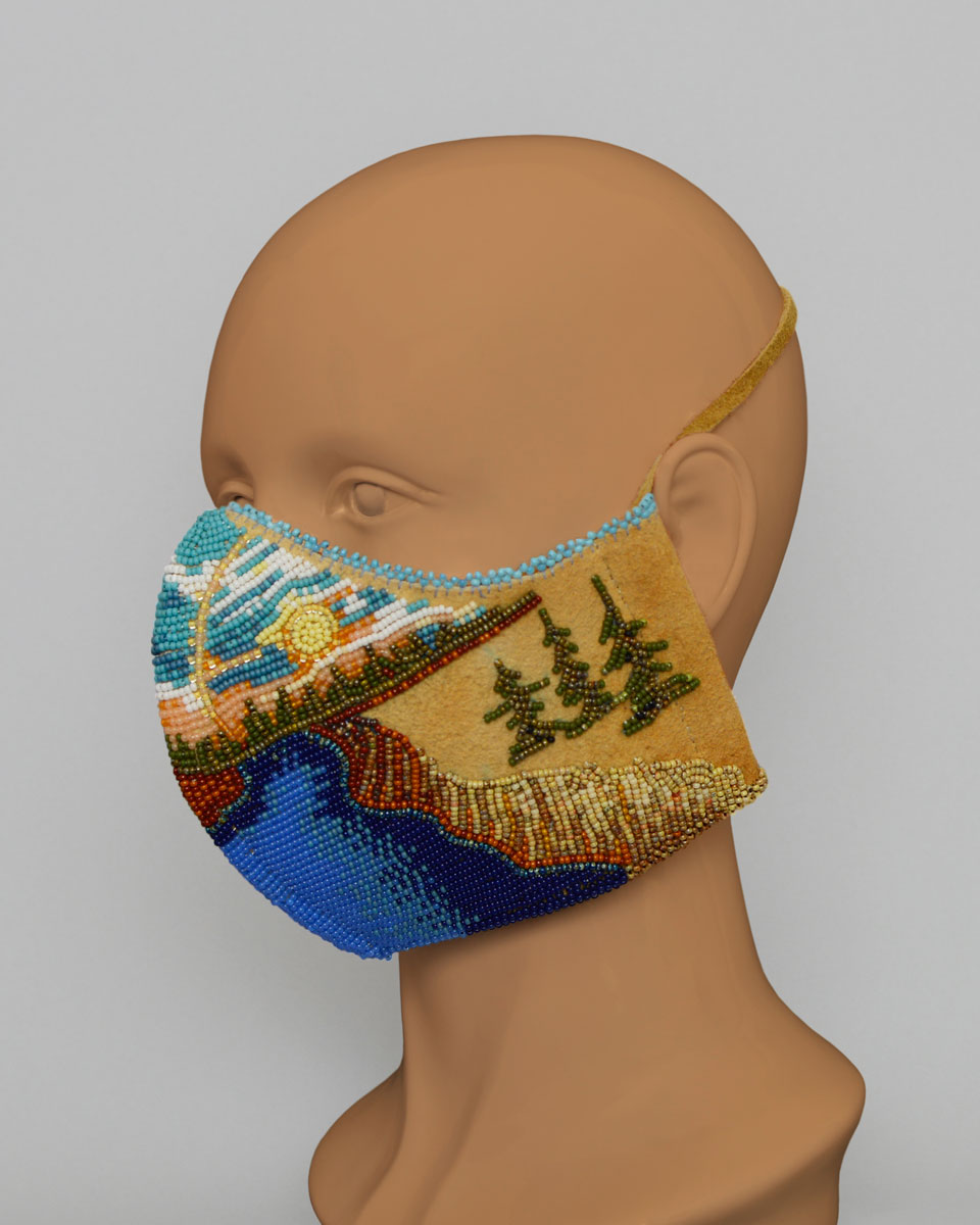 Side view of a mannequin head wearing a leather mask with a beaded landscape