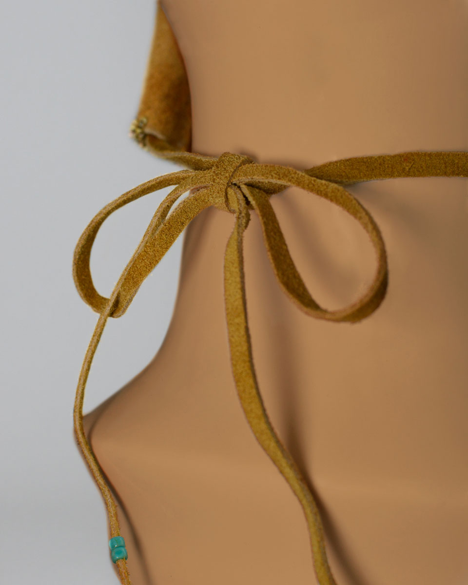 Leather strings tied in a bowtie behind the mannequin's head