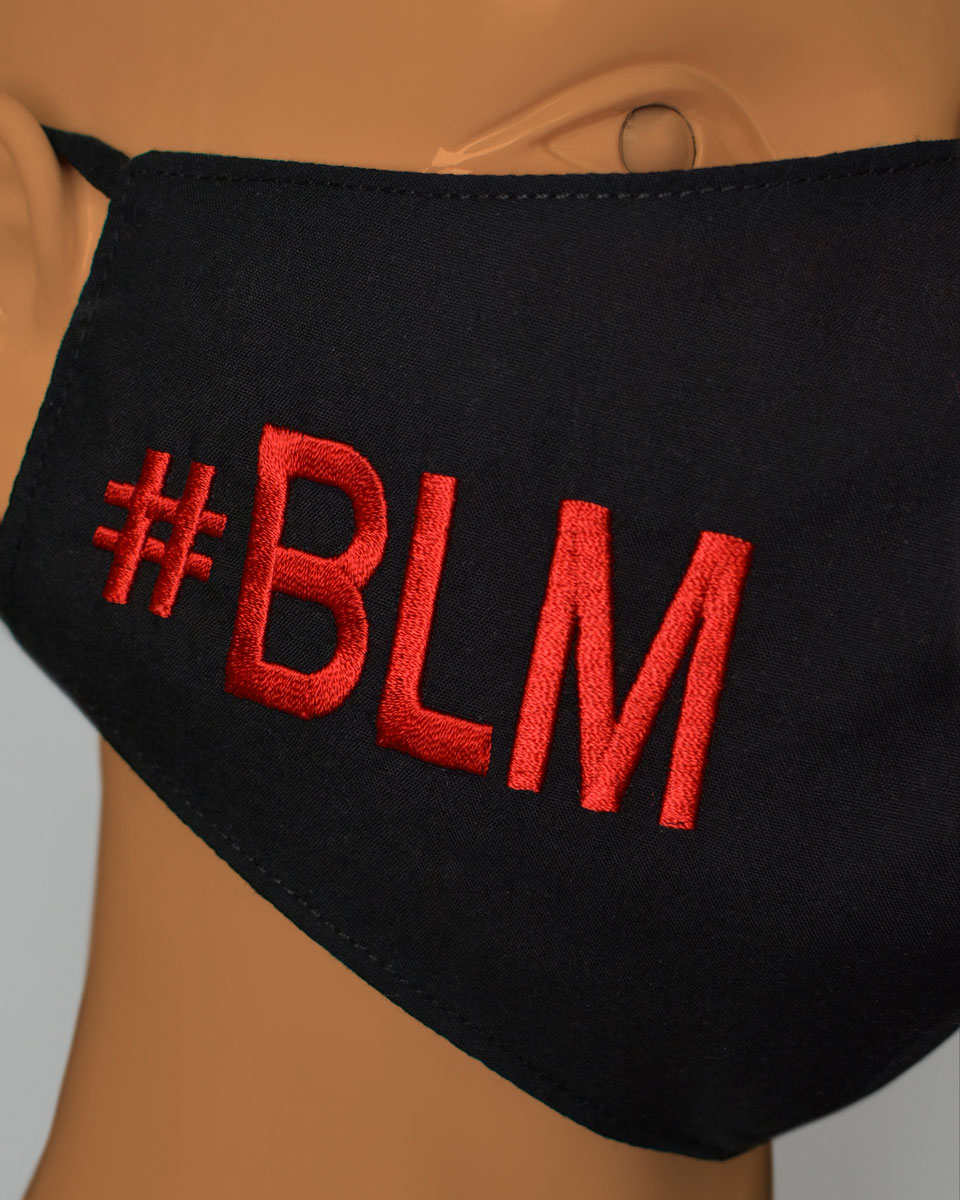 Close up of a mannequin head wearing. black face mask with #BLM embroidered in red.