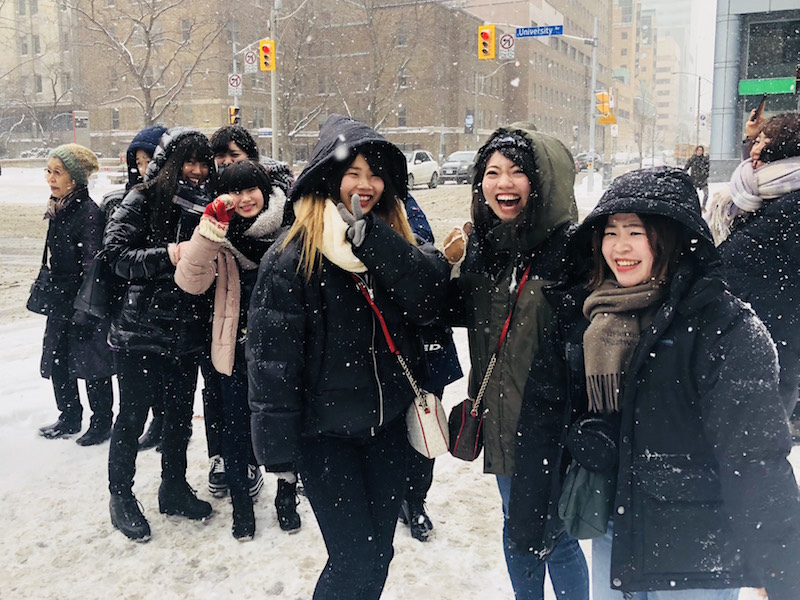 Child studies students from Urawa University outside in the snow.