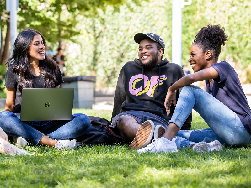 Students sitting on quad laughing together