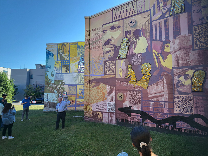 Tmu students admire a Mural from the Mural Arts Philadelphia.