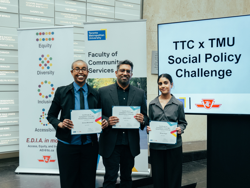A three-student team smiles and shows their winning certificates