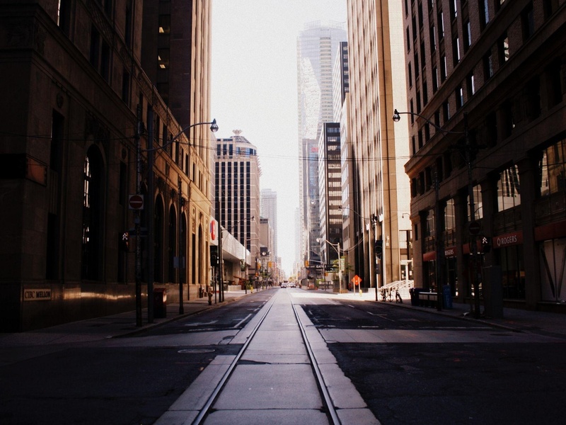 Moody toronto street with sunlight beaming between buildings