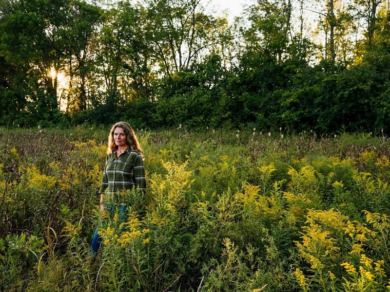 Nina Marie Lister standing in field of flowers