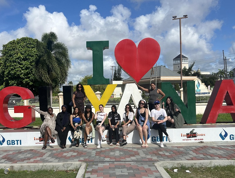 Students pose for a sunny, outdoor photograph in Guyana