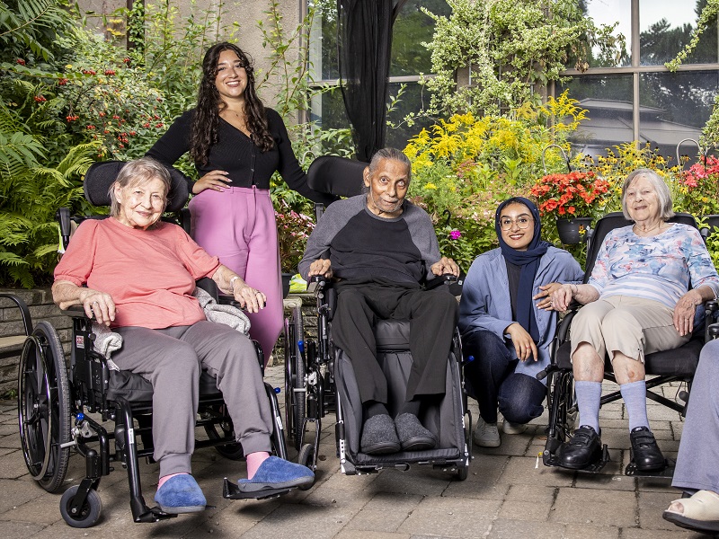 Teri project director poses with three long-term care residents and student