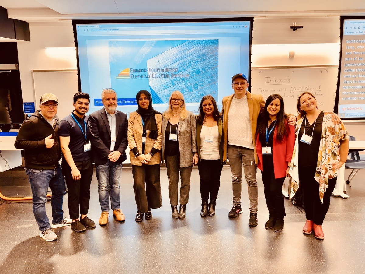 Nine attendees stand for a group shot at the Enhancing Equity in Ontario Elementary Education Symposium