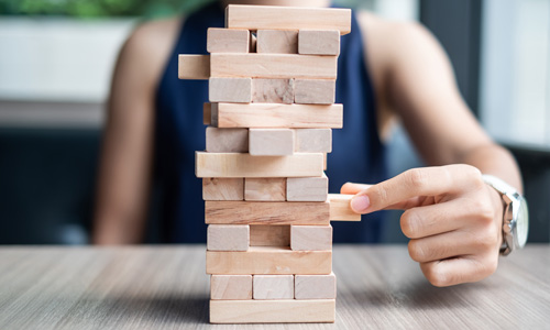 Person pulling Jenga piece out of tower.