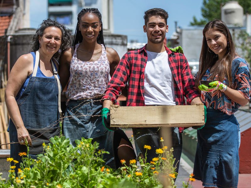 Group gathered around produce in garden setting