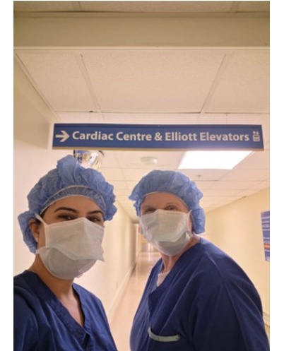 Two professors in a hospital with scrubs and a mask on 