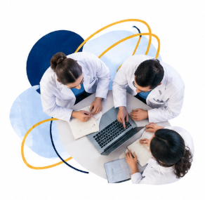 a birds eye view of three students at a table looking at a computer 