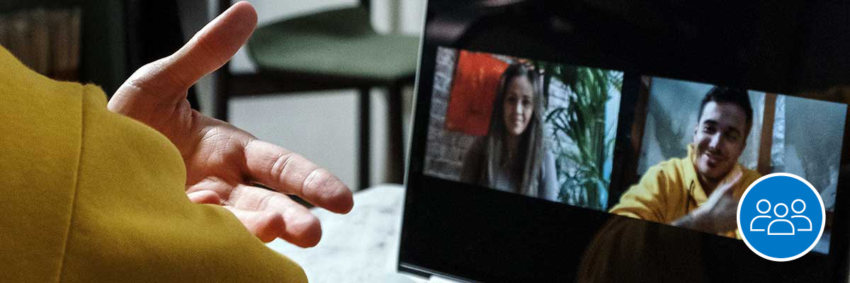 A person in front of their laptop on a Zoom call with two people.