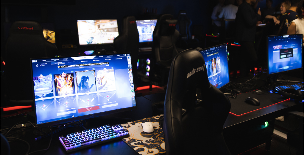 A gaming chair between multiple gaming screens running a multiplayer game.