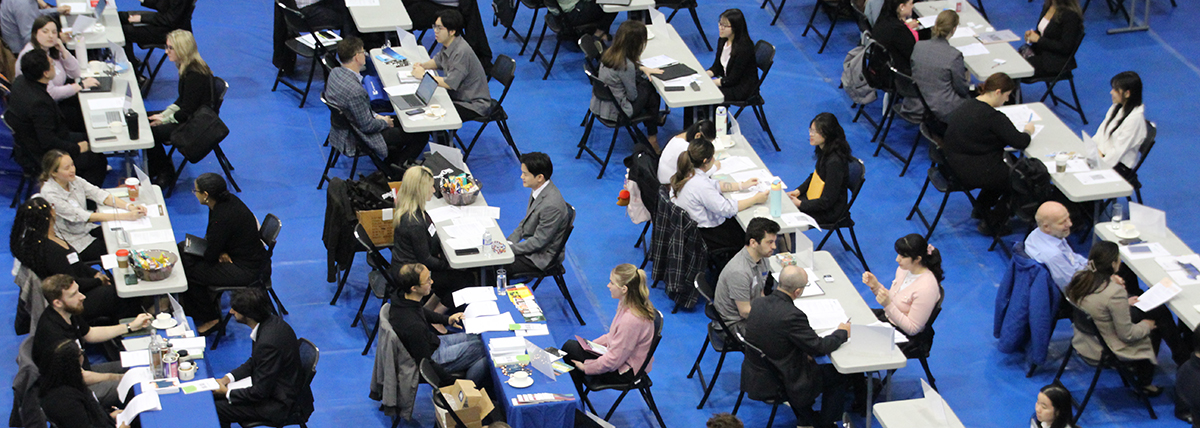 A bird's eye view of the GCM Career Fair with lots of tables with employers and student interviewees