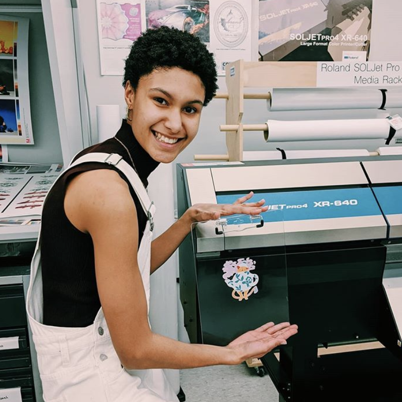 Student posing with their design work