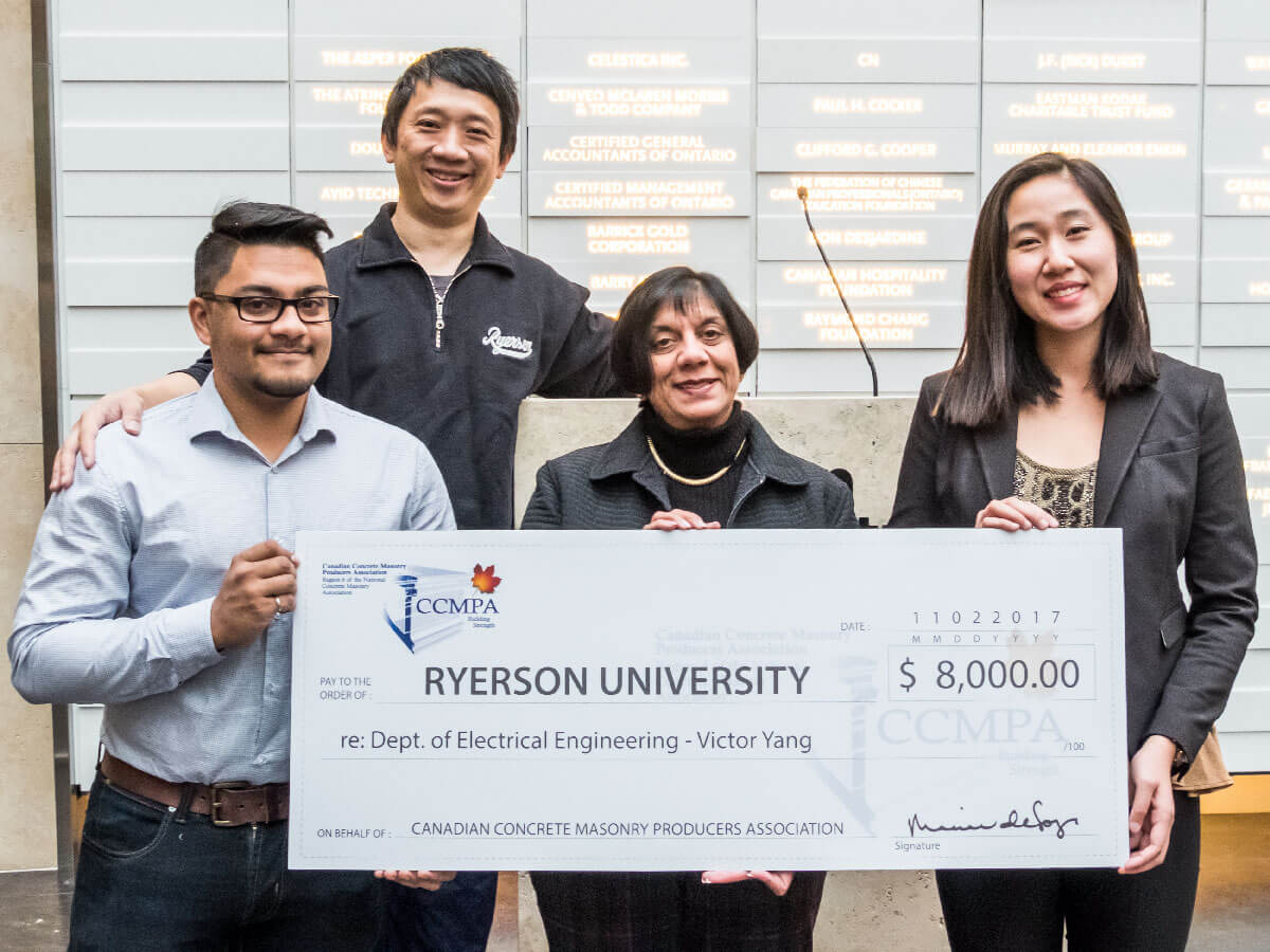 Graduate students Ryan Deorajh and Nhu Nguyen flank Dr. Victor Yang and Marina de Souza posing with giant cheque for $8,000 made out to Ryerson University.