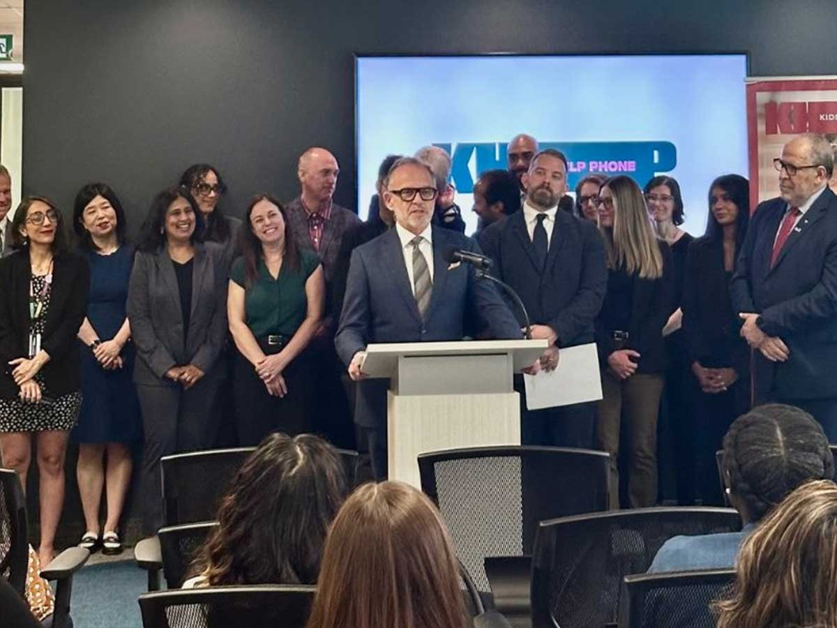 Steven N. Liss, TMU’s vice-president, research and innovation, speaking at the announcement event. Mohamed Lachemi, TMU’s president and vice-chancellor, as well as TMU researchers and Kids Help Phone researchers and executives are in the background.