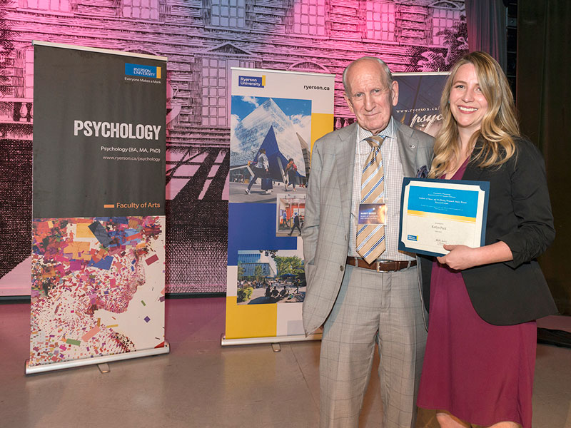 Harry Rosen standing next to Katlyn Peck, who is displaying her award certificate