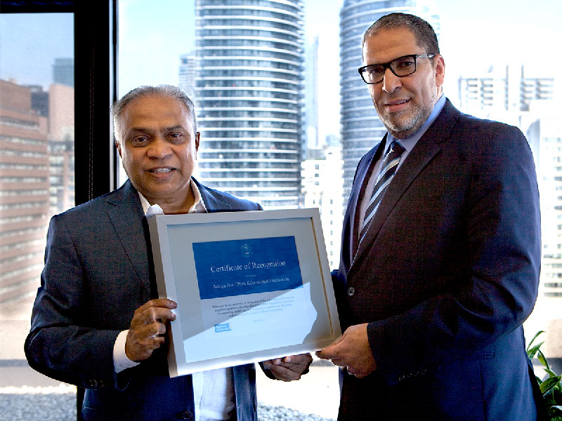 Dr. Aditya holding a framed certificate with Ryerson president Dr. Mohamed Lachemi