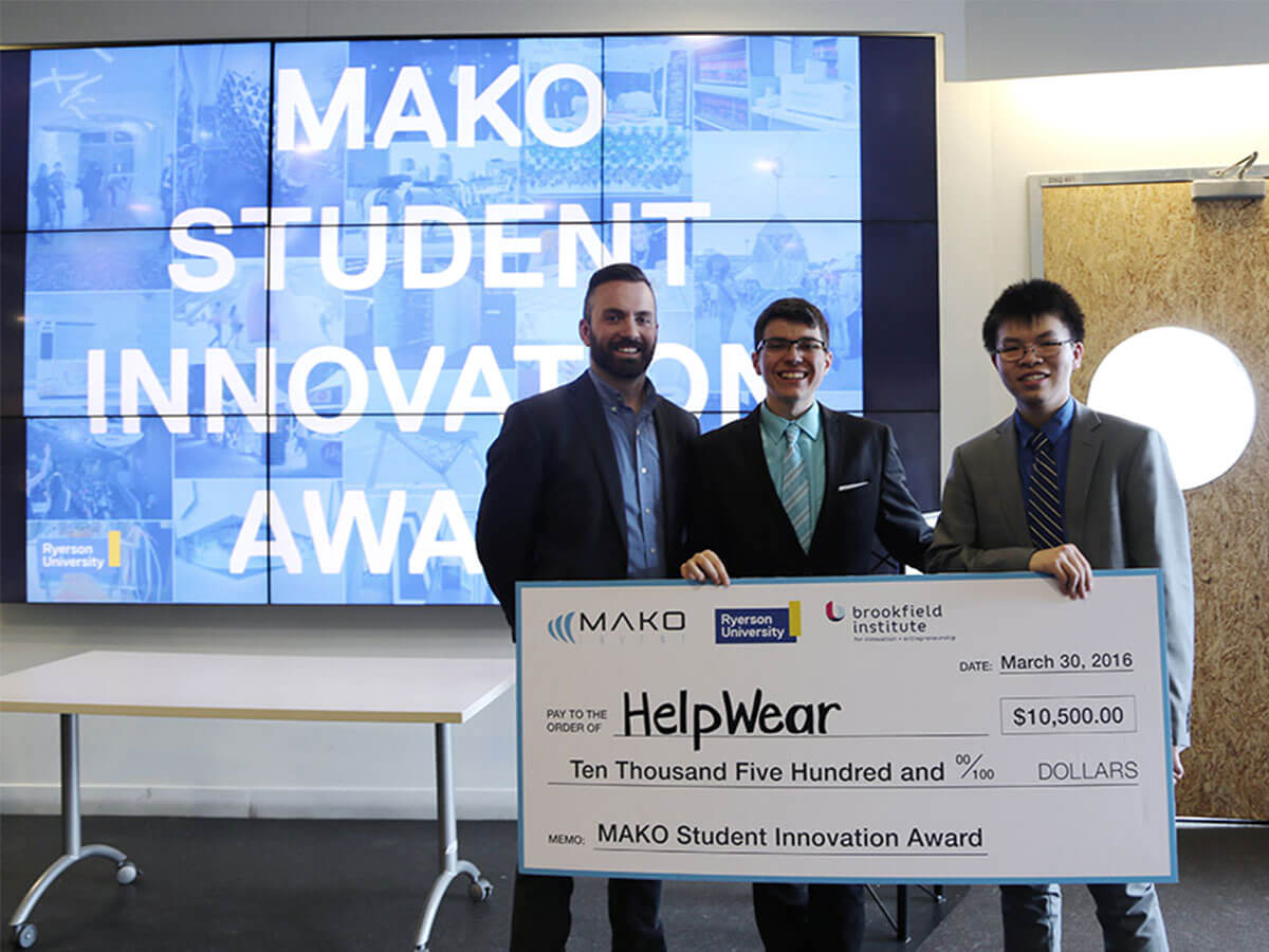 James Chalmers of Mako stands holding a cheque for the award-winning students