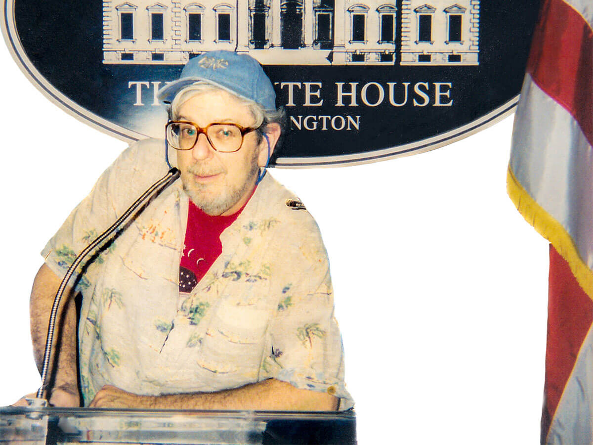 O'Tucky MacLean stand in what seems to be a movie set of the White House conference room podium