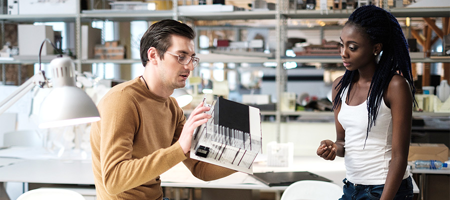 Multiracial couple working in design and engineering architecture office