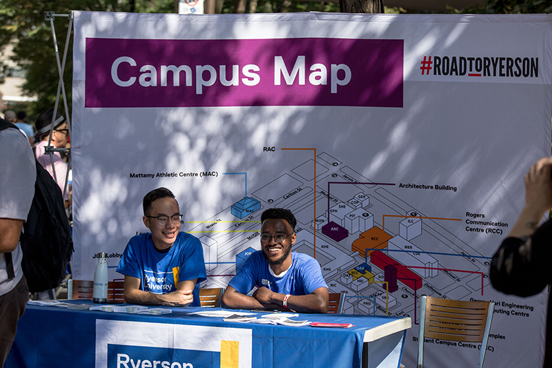 Two student volunteers at the Campus Map booth during Welcome Week. 