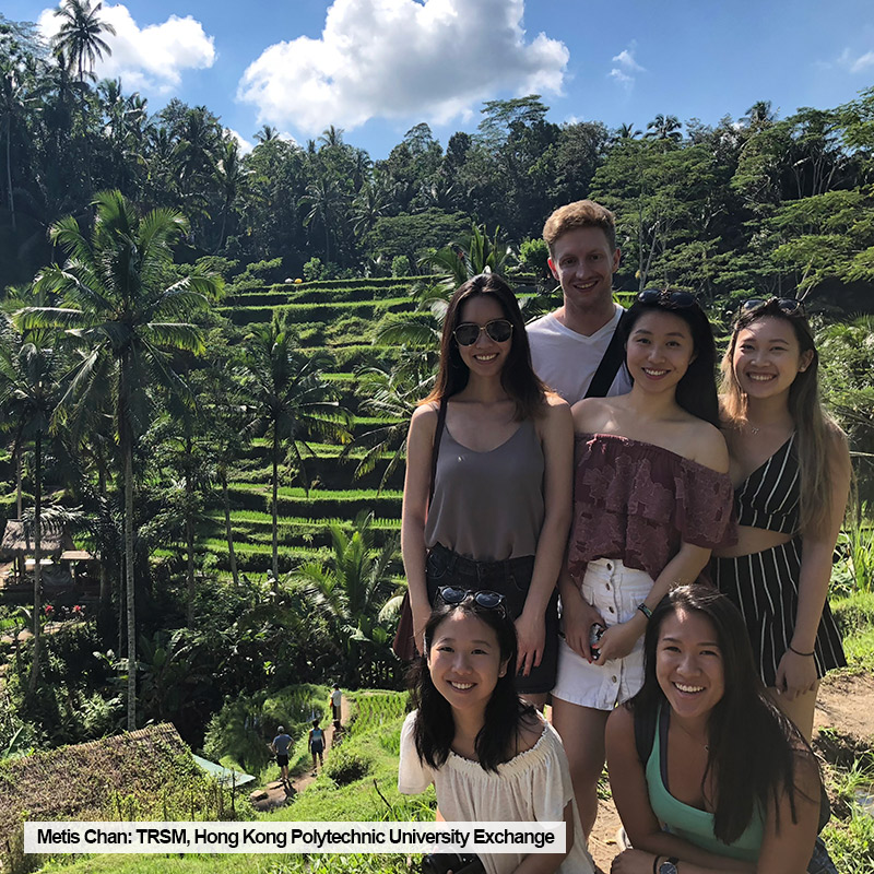 Ryerson TRSM student, Metis Chan, poses with friends in front of a rice field while on exchange at Hong Kong Polytechnic University.